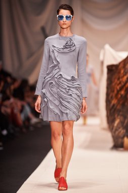 Bir model Alena Akhmadullina podyum üzerinde yürüyor