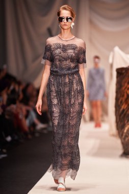 Bir model Alena Akhmadullina podyum üzerinde yürüyor