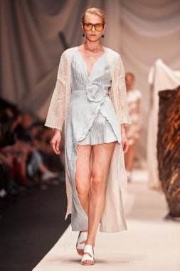 Bir model Alena Akhmadullina podyum üzerinde yürüyor