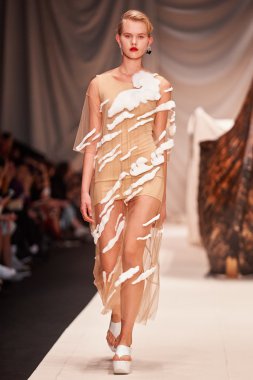 Bir model Alena Akhmadullina podyum üzerinde yürüyor