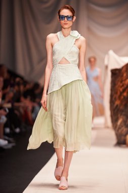 Bir model Alena Akhmadullina podyum üzerinde yürüyor