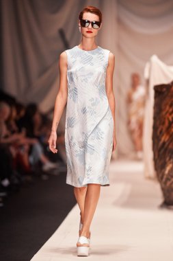 Bir model Alena Akhmadullina podyum üzerinde yürüyor