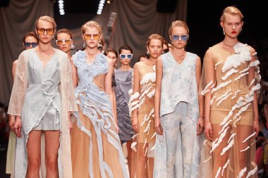 Bir model Alena Akhmadullina podyum üzerinde yürüyor