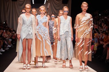 Bir model Alena Akhmadullina podyum üzerinde yürüyor