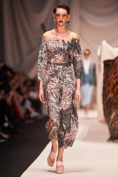 Bir model Alena Akhmadullina podyum üzerinde yürüyor