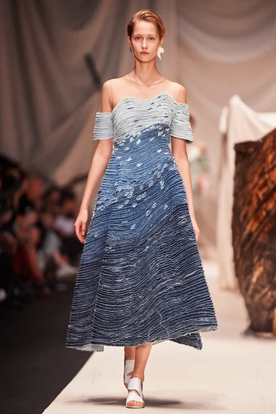 Bir model Alena Akhmadullina podyum üzerinde yürüyor