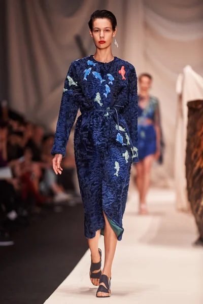 Bir model Alena Akhmadullina podyum üzerinde yürüyor