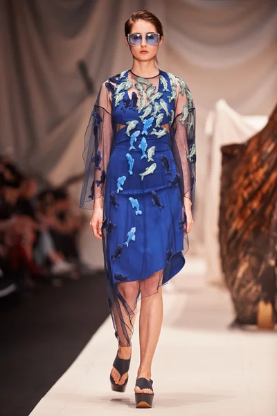 Bir model Alena Akhmadullina podyum üzerinde yürüyor