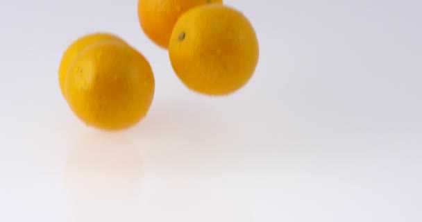 缓慢运动的多汁橙子滴在白色的反射面上 与水一起弹跳 慢慢地落下的果实 风格水果视频 在反光的白色表面上弹跳的燕麦 — 图库视频影像