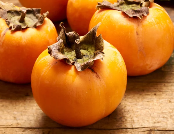 Yummy persimmon on a wooden board — Stock Photo, Image