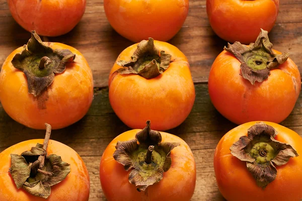 Persimmon resting on an old table — Stock Photo, Image