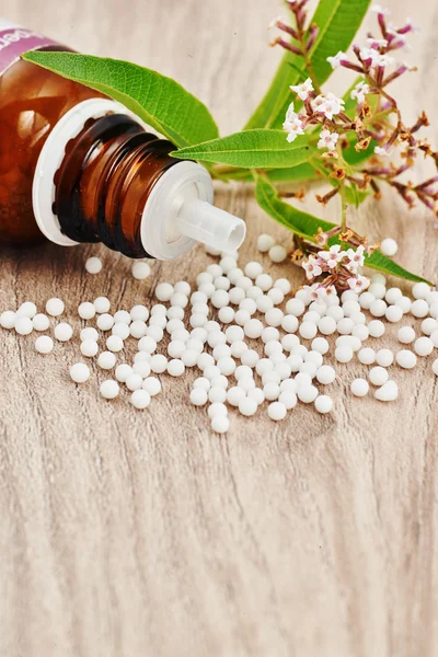 Ahşap bir masa üzerinde dağınık homeopatik granül — Stok fotoğraf