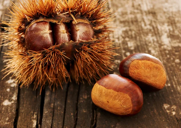 Chestnuts on an old table — Stock Photo, Image