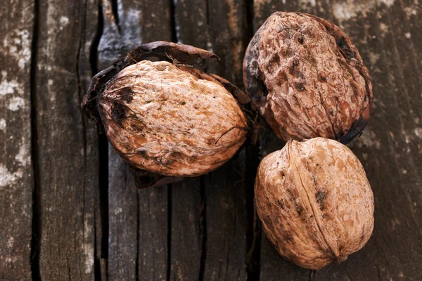 Drie heerlijke walnoten op een oude houten tafel — Stockfoto