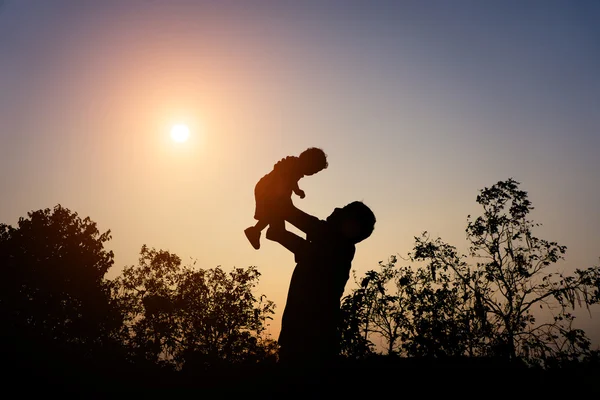 Silueta tatălui ei cu copilul ei împotriva apusului de soare — Fotografie, imagine de stoc