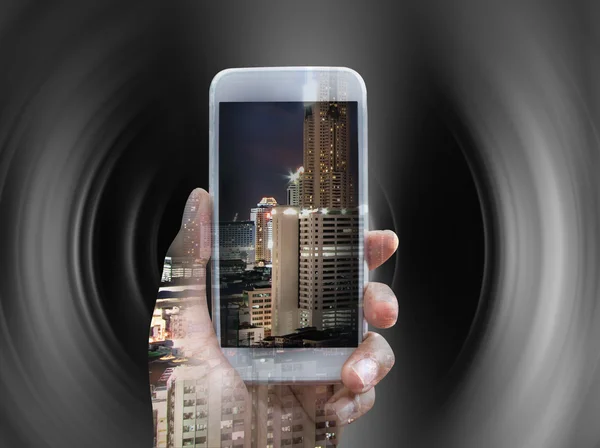 Doble exposición del teléfono inteligente de mano durante la noche de la ciudad — Foto de Stock