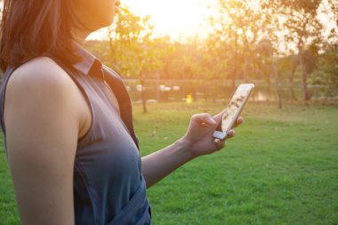 Genç kadın Smartphone yeşil çimenlerin üzerinde dokunmadan