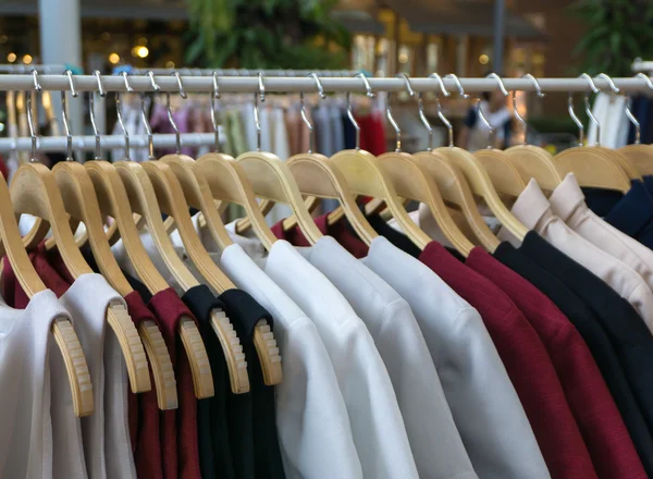 Women clothes hanging on wooden hangers — Stock Photo, Image