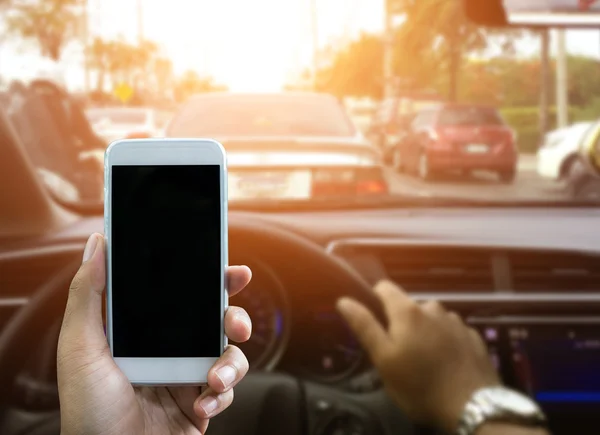 Usando um smartphone enquanto dirige um carro — Fotografia de Stock