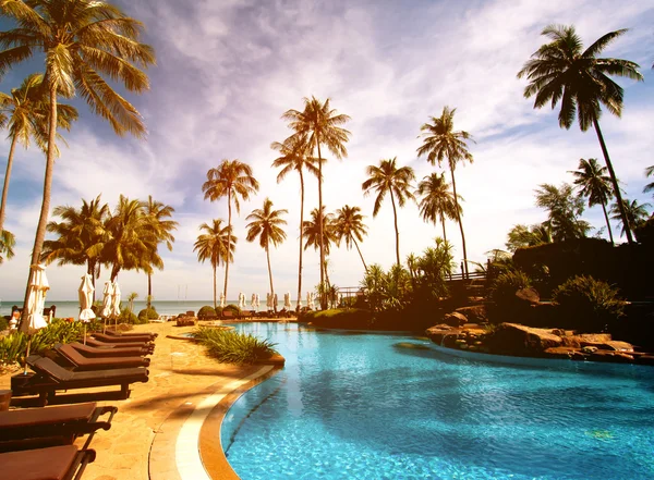 在热带度假村酒店游泳池躺椅 — 图库照片