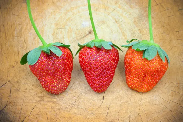 3 fraises sur fond bois — Photo
