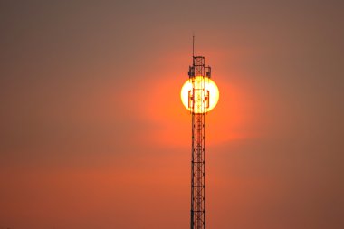 Telecommunications towers at sunset clipart