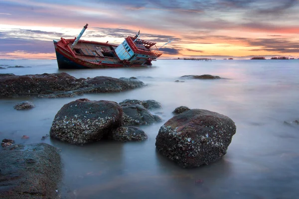 Shipwreck stranded on the beach at sunset — Stock Photo, Image