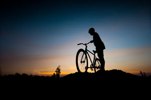 Silhouette dei bambini e bicicletta al tramonto — Foto Stock
