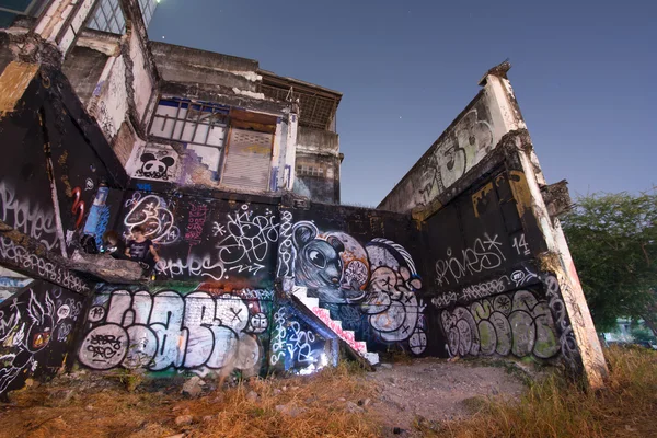 Unbekannter Graffiti-Künstler bemalt verlassene Hauswand — Stockfoto