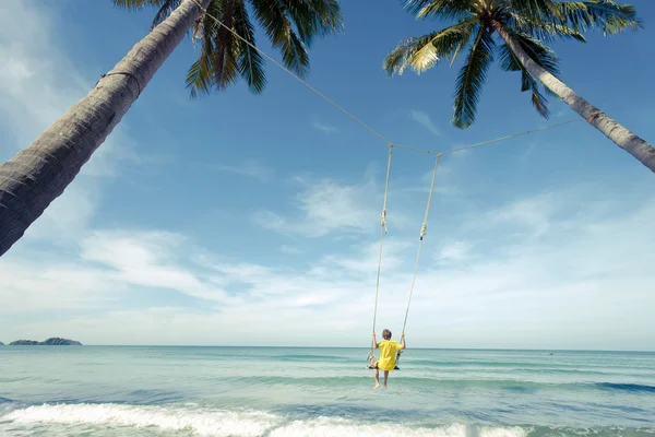 Boy swing in the sea -  vintage effect style