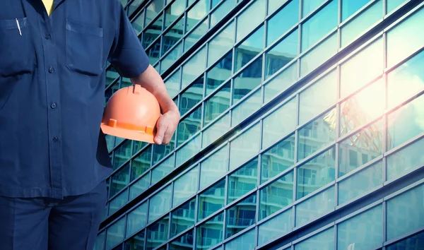 Engenheiro segurando capacete laranja para a segurança dos trabalhadores — Fotografia de Stock