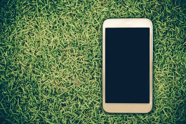 Smartphone sobre hierba fondo — Foto de Stock
