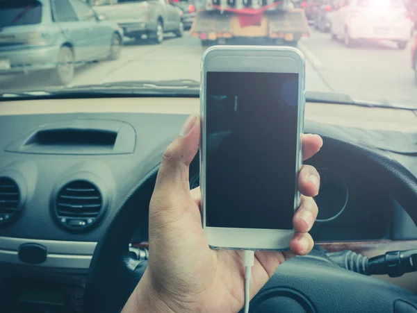 Usar un teléfono inteligente mientras conduce un coche — Foto de Stock