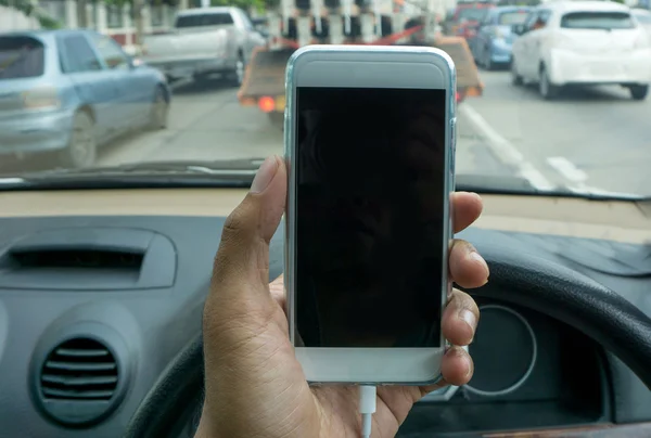 Usando um smartphone enquanto dirige um carro — Fotografia de Stock