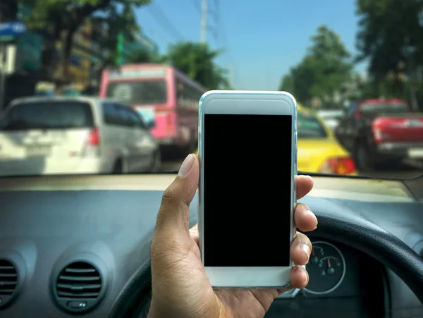Usar un teléfono inteligente mientras conduce un coche — Foto de Stock