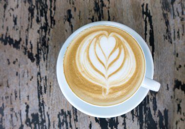 Latte sanat üzerinde ahşap masa kahve bardağı