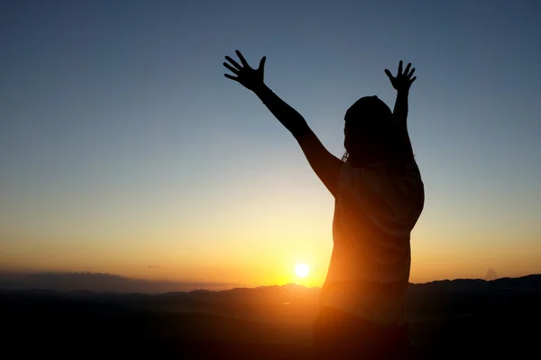 Mujer silueta Manos arriba contra la puesta del sol —  Fotos de Stock