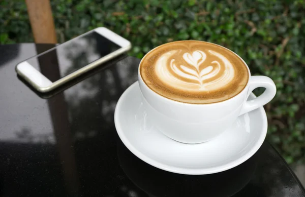 Tazas de café latte arte en mesa negra — Foto de Stock