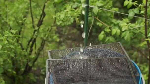 Water is falling down in slow motion into a blue barrel — Stockvideo