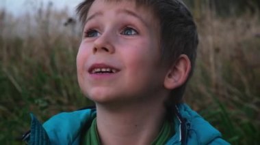 Mavi gözlü, kirli yüzlü, tatlı sarışın çocuk.