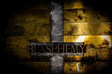 Tersine çevrilmiş kurşun haç üzerine yazılmış küfürlü metin mesajı. Dokulu grunge klasik altın arka planlı.