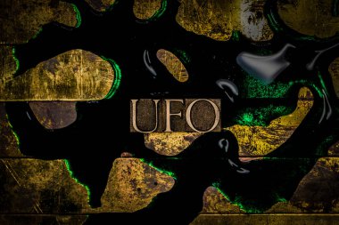 Dokulu grunge bakır zemin üzerinde yeşil sıvı üzerine UFO metni