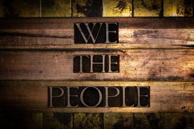 We The People text on vingtage bronze and copper background clipart