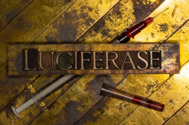 Eski model desenli bakır ve altın arkaplan üzerine şırınga ile Luciferase metin