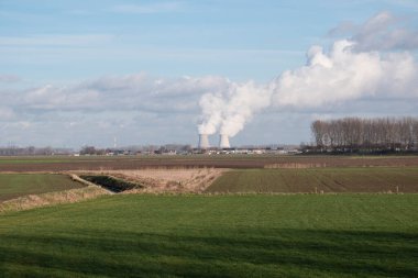 Belçika 'nın Doel kentindeki polen köyünün soğuk kuleleriyle birlikte polderlerin manzara fotoğrafı.