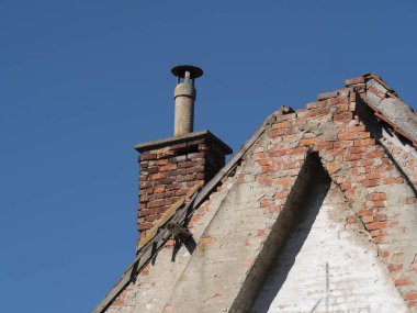 Kırık çatılı çok eski bir binanın bacası.