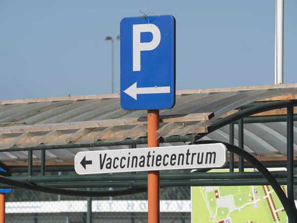 以下の標識で駐車場を示す標識碑文予防接種センターコロナウイルスに対するワクチン接種を与えるために — ストック写真
