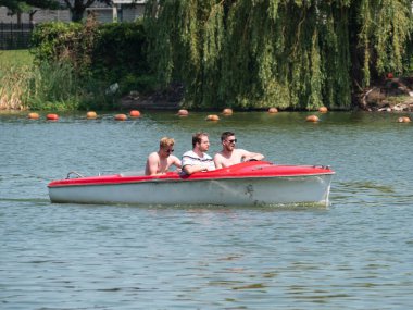 Berlare, Belçika, 22 Temmuz 2021. Üç arkadaş, elektrikli bir tekneyle gölde tekne gezisinin keyfini çıkarıyorlar.