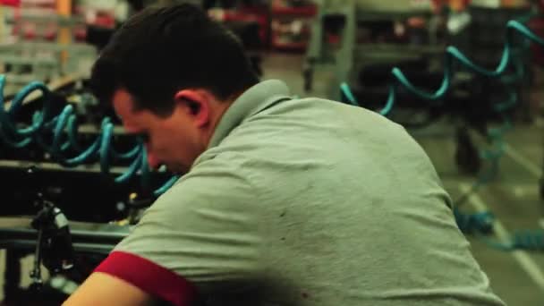 在汽车厂的底盘上工作 工业工人正在修理汽车底盘 — 图库视频影像