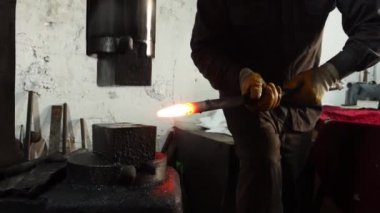 Sıcak kalpazanlık makinesi, atölyede çalışan demirci.